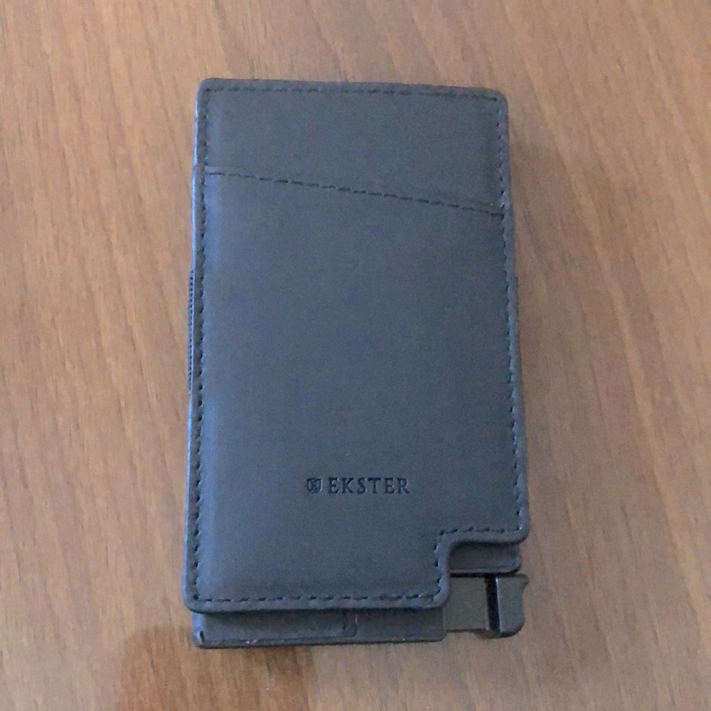 A slim cardholder wrapped in leather with a removable cash strap.